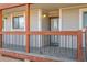 Condo entrance with a wooden porch, railing, and a glass door at 2725 W 86Th Ave # 5, Westminster, CO 80031