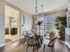 Bright dining room with glass table, wicker chairs, and a view of the kitchen at 11701 Bent Oaks St, Parker, CO 80138