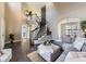 Living room with hardwood floors, gray sectional sofa, and a curved staircase at 11701 Bent Oaks St, Parker, CO 80138