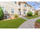 Tan three-story townhome with landscaping and walkway at 1536 Sepia Ave, Longmont, CO 80501