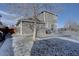 View of backyard with patio, home exterior, and tree casting shadows on snowy ground at 12218 S Oak Bluff Trl, Parker, CO 80134