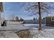 Backyard patio and concrete area with stone fence in a snow-covered yard at 12218 S Oak Bluff Trl, Parker, CO 80134