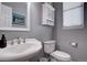 Bathroom featuring a modern pedestal sink, toilet, and decorative cabinet at 12218 S Oak Bluff Trl, Parker, CO 80134