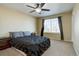 Bedroom with a ceiling fan, large window, and neutral-colored walls create a relaxing atmosphere at 12218 S Oak Bluff Trl, Parker, CO 80134