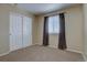 Cozy bedroom with neutral carpet, sliding door closet, and a window for natural light at 12218 S Oak Bluff Trl, Parker, CO 80134