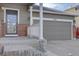 Close up view of a home's front door and 2-car garage and brick base at 12218 S Oak Bluff Trl, Parker, CO 80134