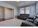 Inviting living room featuring neutral carpet and large windows, leading into the entryway at 12218 S Oak Bluff Trl, Parker, CO 80134