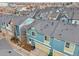 Beautiful aerial shot shows modern colorful townhomes featuring attached garages and well-kept exteriors at 2212 Tamarac St, Denver, CO 80238