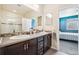 Bathroom featuring a double sink vanity and a doorway leading into the bedroom at 2212 Tamarac St, Denver, CO 80238