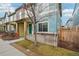 Charming two-story home with a welcoming teal-colored front door and cozy yard at 2212 Tamarac St, Denver, CO 80238