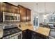 Well-equipped kitchen with stainless steel appliances, granite countertops, and dark wood cabinets at 2212 Tamarac St, Denver, CO 80238