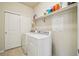 Functional laundry room equipped with washer, dryer, and shelving for storage at 2212 Tamarac St, Denver, CO 80238