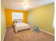 Bright bedroom with yellow and green walls has a queen bed and ceiling fan at 7627 Halleys Dr, Littleton, CO 80125