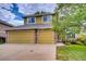 Charming two-story home featuring a three-car garage with stone accents, plus manicured lawn and mature landscaping at 7627 Halleys Dr, Littleton, CO 80125