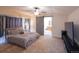 Spacious main bedroom with a sliding barn door to ensuite bathroom, ceiling fan, and carpet floors at 7627 Halleys Dr, Littleton, CO 80125
