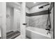 Bathroom with white tub and tiled wall with black plumbing fixtures at 9591 W Florida Pl, Lakewood, CO 80232