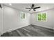 Bright bedroom featuring wood-look flooring, a ceiling fan, and natural light from two windows at 9591 W Florida Pl, Lakewood, CO 80232