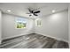 Bright bedroom featuring wood-look flooring, a ceiling fan, and natural light from two windows at 9591 W Florida Pl, Lakewood, CO 80232