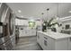 A well-lit, updated kitchen with white cabinets, island and stainless steel appliances at 9591 W Florida Pl, Lakewood, CO 80232