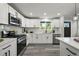 Bright kitchen featuring modern white cabinetry, stainless appliances, and stylish backsplash at 9591 W Florida Pl, Lakewood, CO 80232