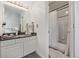Updated bathroom featuring a modern vanity, large mirror, stylish lighting, and a shower-tub combo at 6260 Everett Ct # D, Arvada, CO 80004