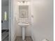 Well-lit powder room featuring stylish gray flooring, a pedestal sink, and a clean, modern aesthetic at 6260 Everett Ct # D, Arvada, CO 80004