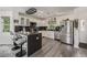 Modern kitchen with breakfast bar, stainless steel appliances, and wooden floors at 6260 Everett Ct # D, Arvada, CO 80004