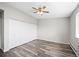 Bright bedroom featuring wood flooring, neutral walls, ceiling fan, and closet at 495 S Dayton St # 1D, Denver, CO 80247