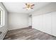 Bedroom featuring wood flooring, neutral walls, bright window, and closet at 495 S Dayton St # 1D, Denver, CO 80247