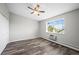 Bright bedroom featuring wood flooring, neutral walls, a ceiling fan, and a window with a view at 495 S Dayton St # 1D, Denver, CO 80247