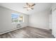 Bedroom featuring wood flooring, neutral walls, a ceiling fan, and a bright window at 495 S Dayton St # 1D, Denver, CO 80247