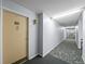 Hallway featuring neutral walls, carpet, and unit doors with lighting at 495 S Dayton St # 1D, Denver, CO 80247