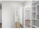 Bright hallway leading to a bathroom and bedroom with a view of the built-in shelving at 495 S Dayton St # 1D, Denver, CO 80247