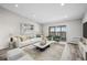 Staged living room with modern furnishings and sliding glass doors to a balcony at 495 S Dayton St # 1D, Denver, CO 80247