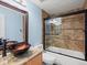 Bathroom featuring a glass bowl sink, granite countertops, and a tiled shower/tub combo with glass doors at 5541 S Eaton St, Littleton, CO 80123