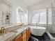 This primary bathroom has a soaking tub, step-in shower, and double sinks at 5541 S Eaton St, Littleton, CO 80123