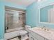 Bright bathroom featuring a large mirror, white vanity, and a shower-tub combination with tile surround at 5541 S Eaton St, Littleton, CO 80123