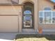 Close up of a well-designed front entrance with a garage, lovely archway and lots of natural light at 5541 S Eaton St, Littleton, CO 80123