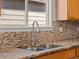 Granite countertops, stainless steel sink, and mosaic backsplash accent this well lit kitchen space at 5541 S Eaton St, Littleton, CO 80123