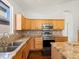 Well-lit kitchen features wood cabinets, stainless steel appliances, mosaic backsplash, and granite countertops at 5541 S Eaton St, Littleton, CO 80123