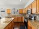 Bright kitchen features wood cabinets, stainless steel appliances, granite countertops, and mosaic backsplash at 5541 S Eaton St, Littleton, CO 80123