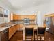 Spacious kitchen showcasing an island, stainless steel appliances, and warm-toned cabinetry at 5541 S Eaton St, Littleton, CO 80123
