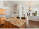 Open floorplan with granite island and stainless steel appliances leads into a bright living area with a fireplace at 5541 S Eaton St, Littleton, CO 80123