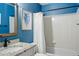 Clean bathroom with blue walls, a shower-tub combination, and a stylish granite countertop sink at 6577 Esperanza Dr, Castle Pines, CO 80108