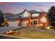 Beautiful brick home with a manicured lawn, three-car garage and charming front patio seating area at 6577 Esperanza Dr, Castle Pines, CO 80108
