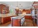 Spacious kitchen with custom wood cabinets, granite countertops, a large center island, and pendant lighting at 6577 Esperanza Dr, Castle Pines, CO 80108