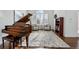 Elegant living room with a grand piano, large windows, and stylish furnishings at 6577 Esperanza Dr, Castle Pines, CO 80108