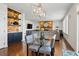 Open-concept living room featuring a stone fireplace, modern chandelier, and a built-in bar with shelving at 6577 Esperanza Dr, Castle Pines, CO 80108