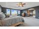 Spacious main bedroom with a large bed, fireplace, and picturesque views from the expansive windows at 6577 Esperanza Dr, Castle Pines, CO 80108