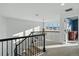 Bright staircase landing leading to upper level, featuring carpeted stairs and wrought iron railing at 6577 Esperanza Dr, Castle Pines, CO 80108